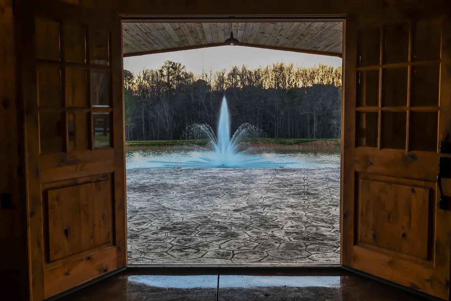 Pond fountain framed by the open barn doors at Grant Gables Venue