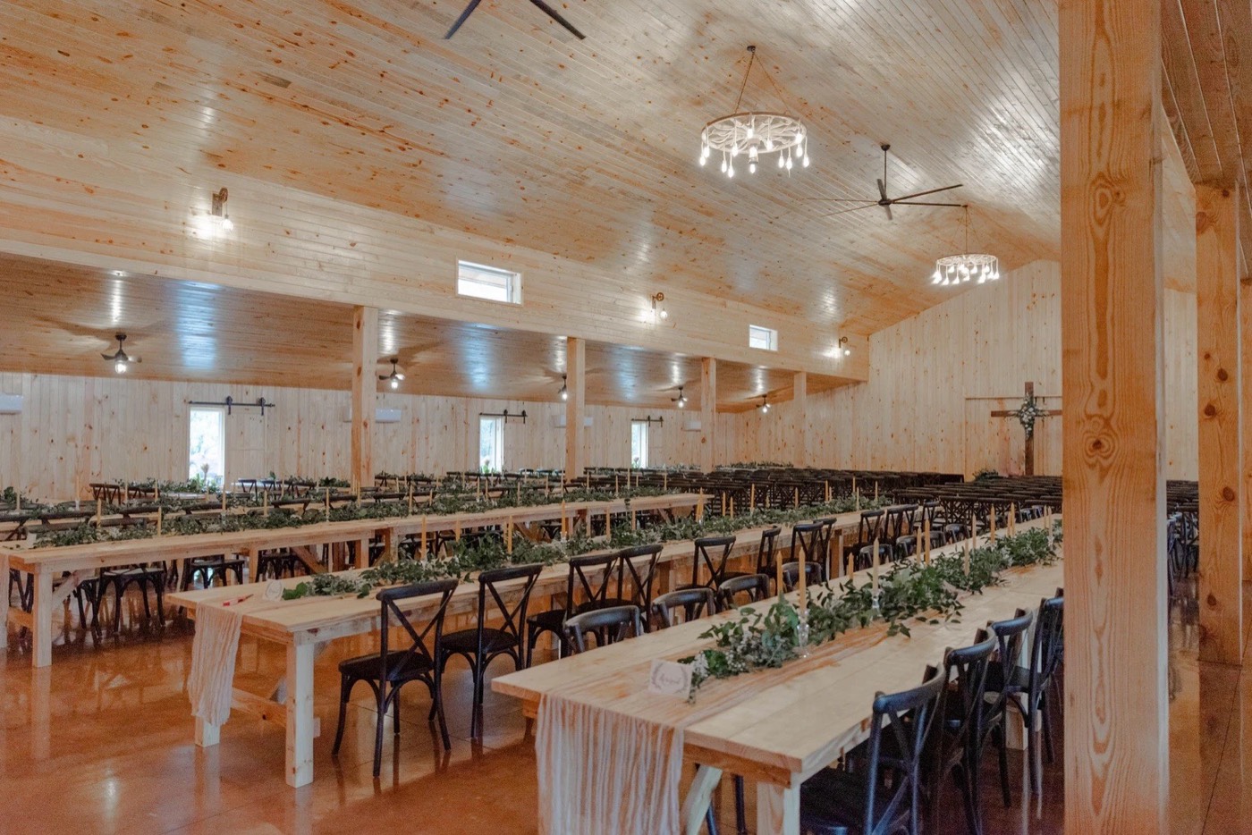 Reception banquet tables dressed and set inside the climate-controlled barn