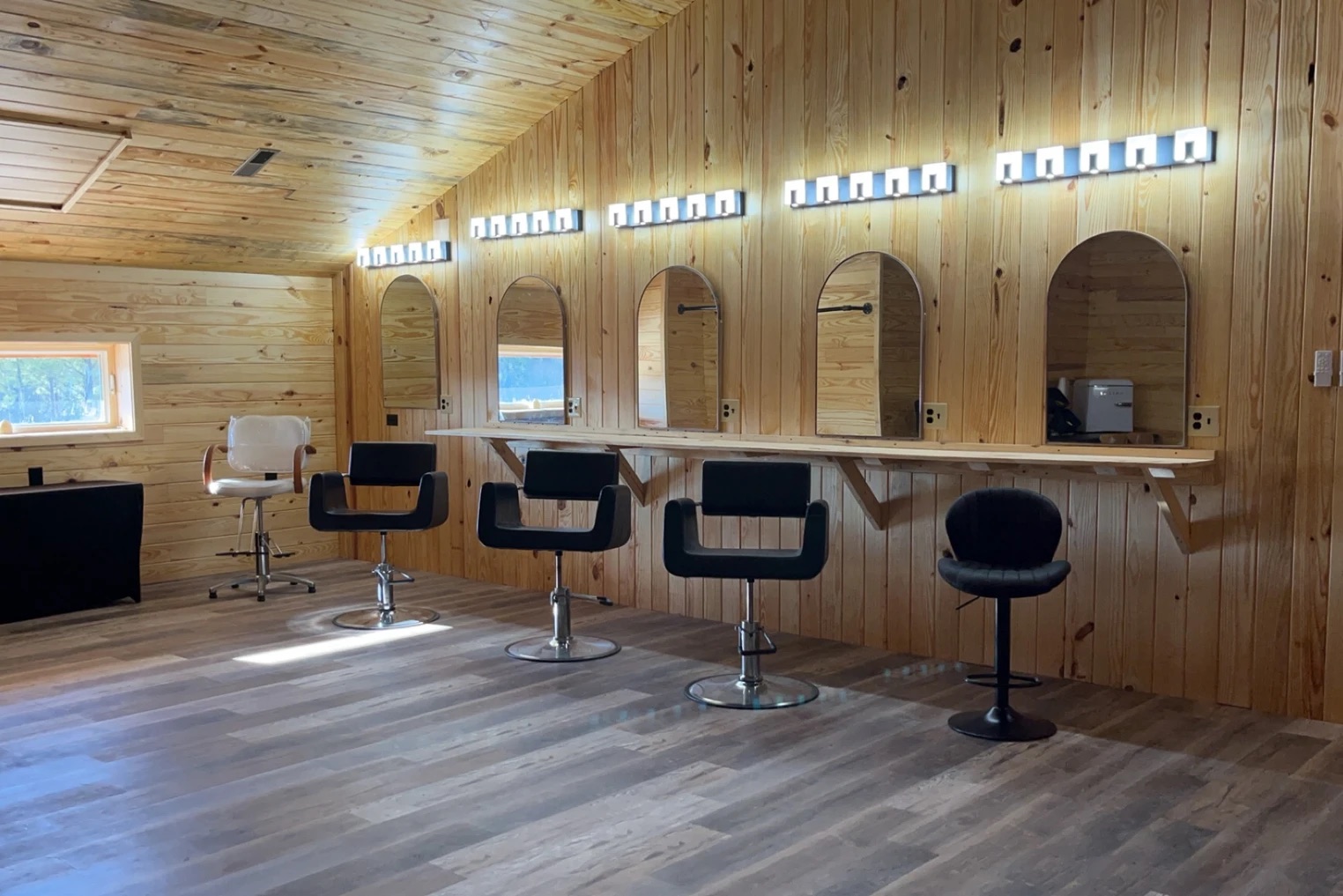 Bridal suite styling stations with salon chairs and lighted mirrors